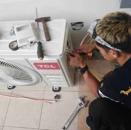 Illustrative technician checking the connections on a compact outdoor condenser